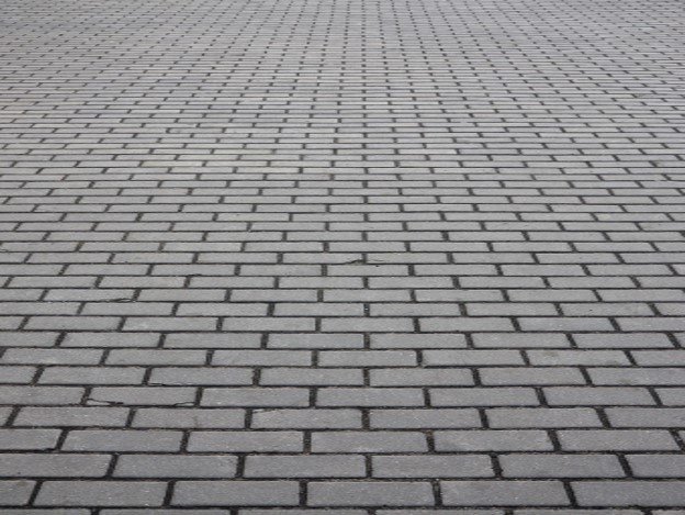 Gray brick paver driveway installed in a running bond pattern for residential property in Eastlake, OH