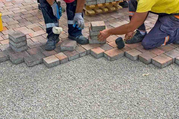 Concrete contractors installing paver driveway edge with gravel base preparation in Eastlake, OH
