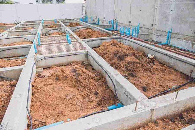 Concrete foundation installation with footing layout and plumbing lines prepared for residential build in Eastlake, OH