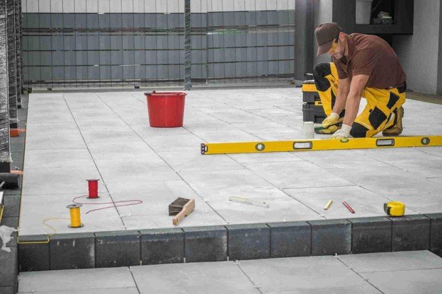 Contractor using a level tool to align large concrete patio slabs during installation in Eastlake, OH