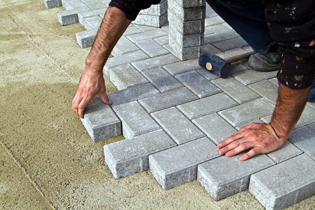 Contractor installing concrete pavers for patio construction on a compacted base in Eastlake, OH