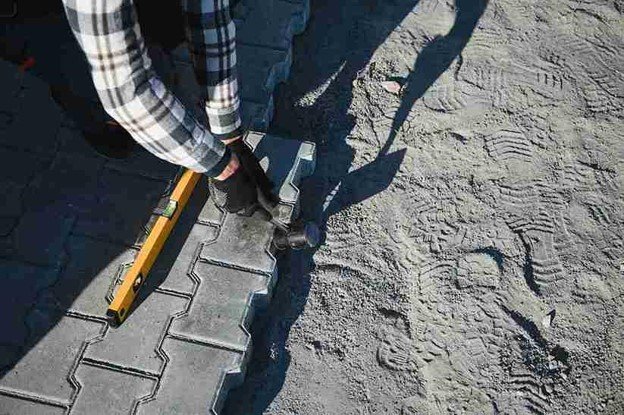 Stamped concrete installation with worker shaping and finishing textured surface in Eastlake, OH