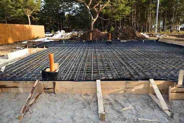 Concrete slab preparation with steel rebar reinforcement grid before pouring foundation in Eastlake, OH