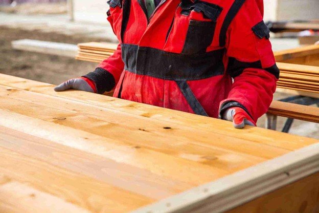 A man with red shirt holding deck.