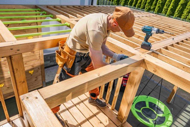 A man working on pergola with a tool right beside.
