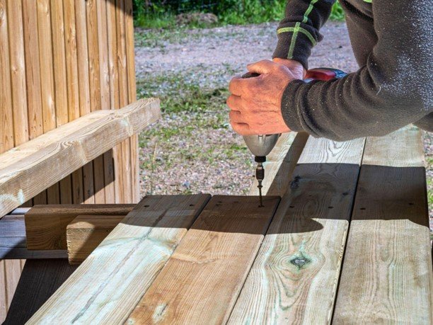 A professional worker drilling for deck remodeling.