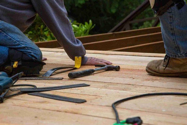 Two worker with tools on the ground doing repair.